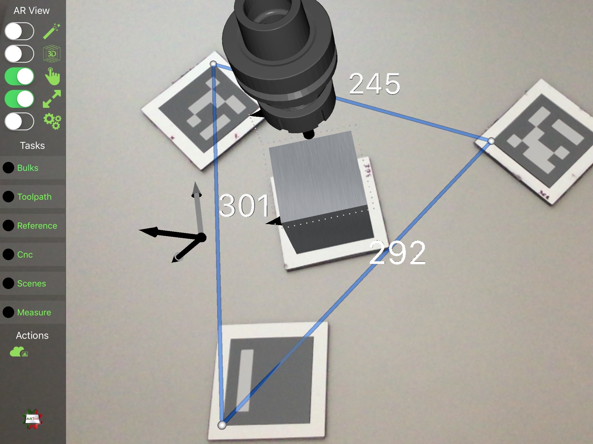 Screenshot of ARTool iPad app, showing the setup-mode augmented reality view. In this case, three markers are used for measuring distances, while the central one provides ego-localization to the device camera and its position provides the reference for rendering the tool holder, the block-form, and the toolpath (as a sequence of white dots)